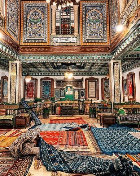 An intricately decorated room with ornate carpets, traditional furniture, and detailed wall and ceiling artwork. 4