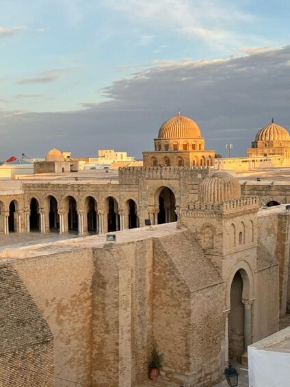 A historic cityscape with domed buildings and arched walkways. 5