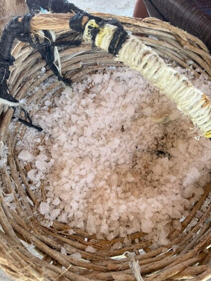 A woven basket filled with pink salt crystals. 2