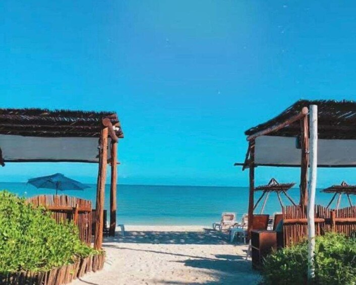A beach with wooden structures and umbrellas. 4