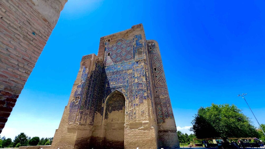 A historic tower with intricate blue tile patterns and a large arched entrance. 3