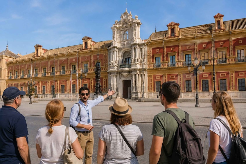A group of tourists observing a historic building with a central bell tower. 3