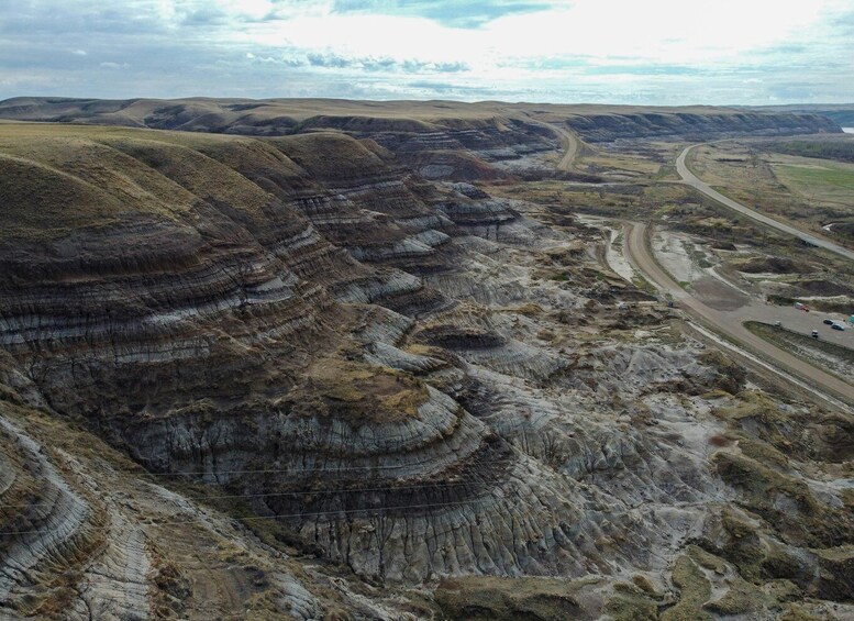 A vast landscape with layered rock formations and a winding road. 2