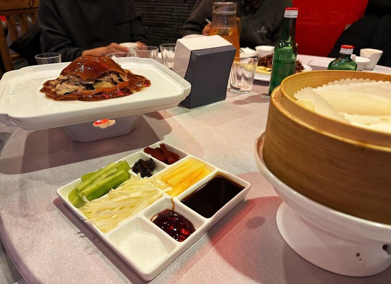 A table with a roasted duck, various side dishes, and a large cake. 3