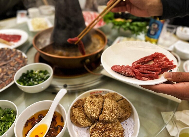 A hot pot meal with various ingredients and a steaming pot in the center. 1