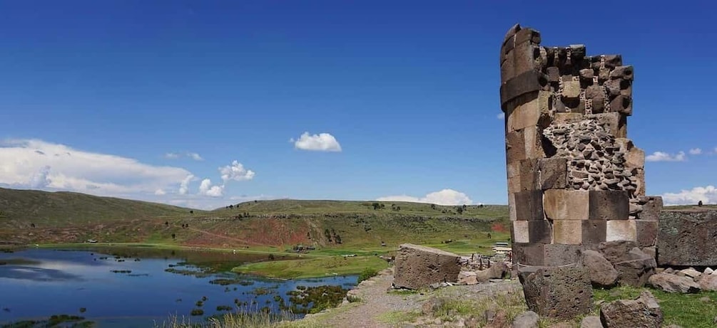 A stone ruin with a pond in a hilly landscape. 1