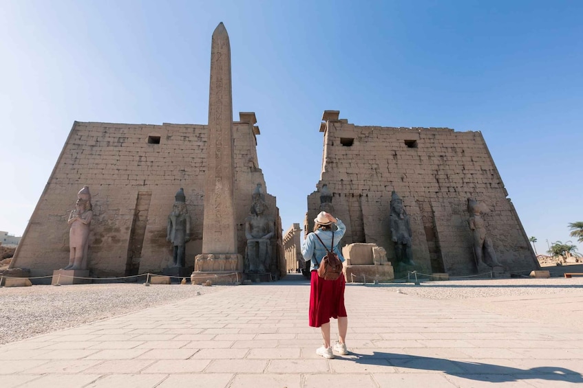 A historical site with a tall obelisk and statues. 5