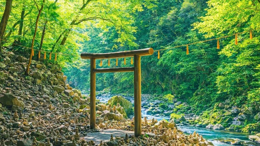 A wooden archway with 'Welcome' written on it, surrounded by a lush green forest and a flowing river. 1