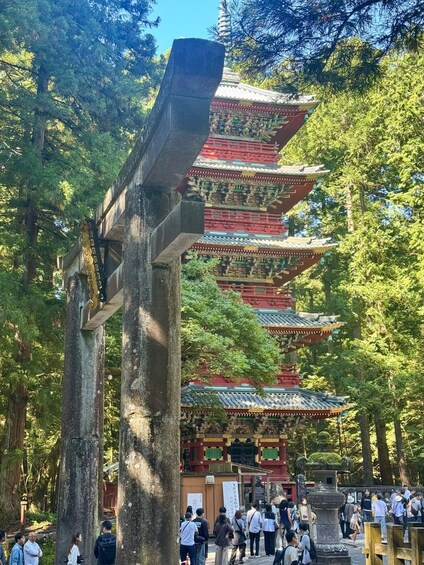 A traditional Japanese pagoda with multiple tiers, surrounded by lush greenery and a crowd of visitors. 3