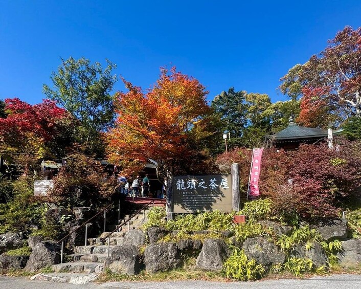 A stone staircase leading up to a traditional Japanese building with a sign in Japanese. 4