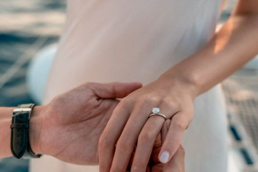 A person wearing a watch and a ring on their left hand. 1