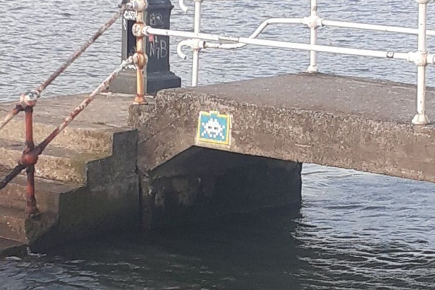 A bridge with a sign, metal railing, and water. 4