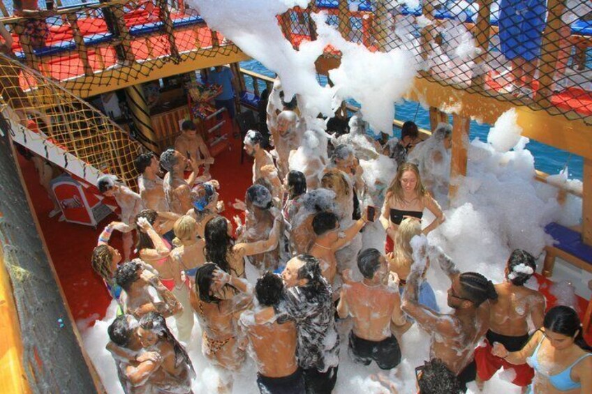 A group of people playing with foam in a water park. 4