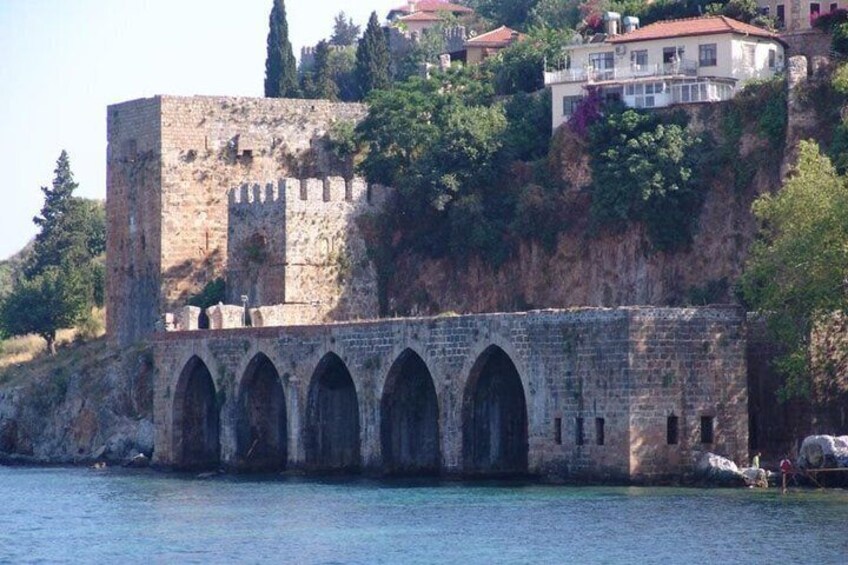 A historic stone bridge with arches, a castle on a hill, and a body of water. 3