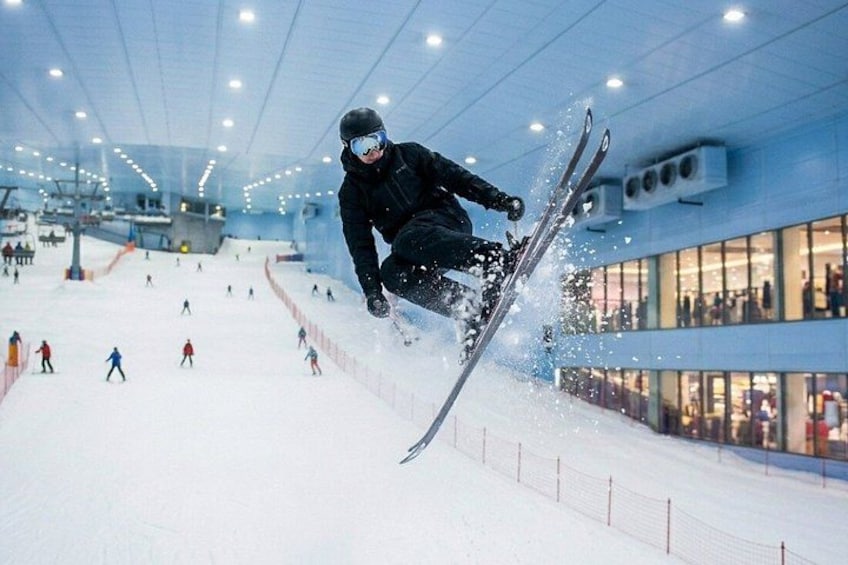En person udfører et spring i en indendørs skihal. 3
