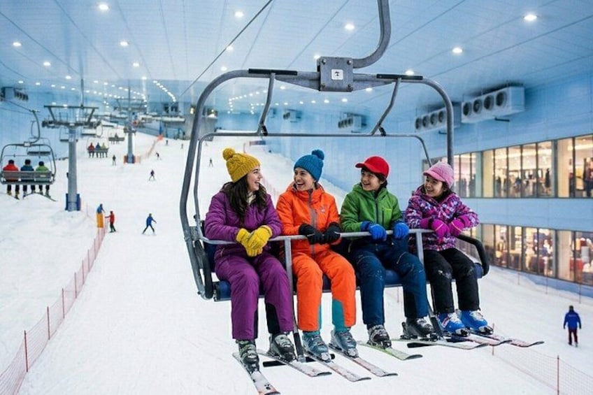 En skilift med skiløbere i farverigt vintertøj. 2