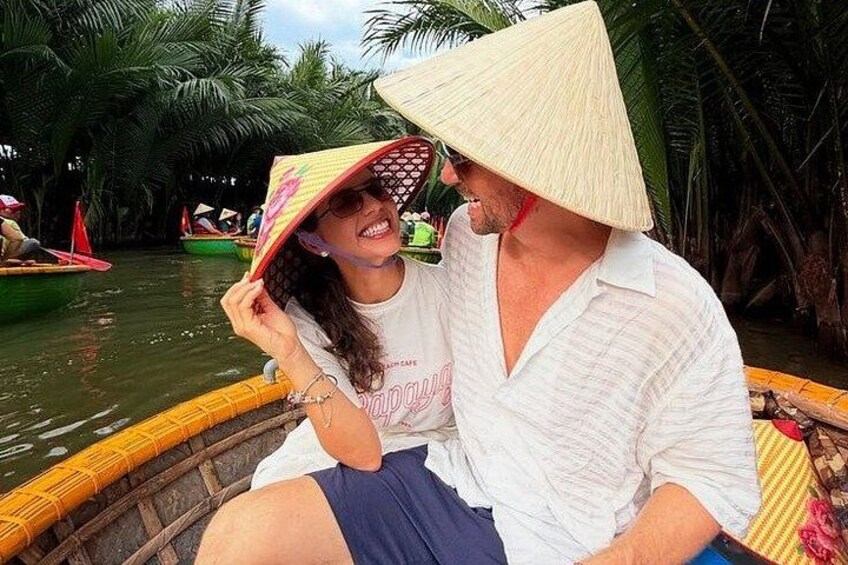 Dos personas en un bote, con un sombrero cónico, rodeadas de palmeras y agua. 1