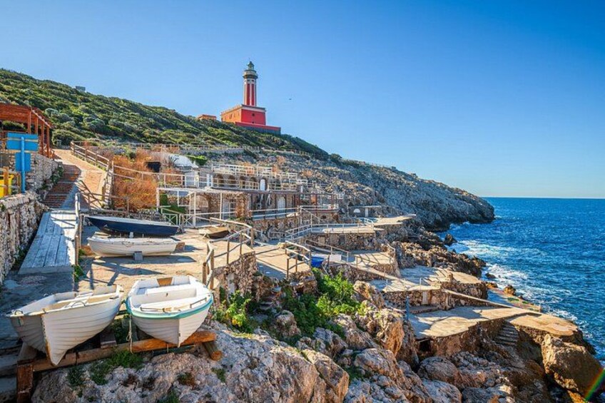 A coastal town with boats, a lighthouse, and rocky terrain. 4