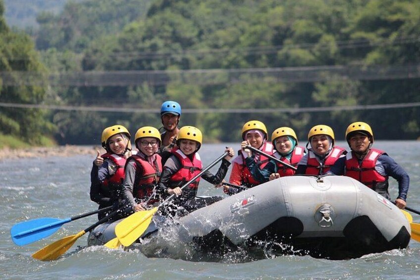 Eine Gruppe von Menschen in einem Floß auf einem Fluss, mit Helmen und Rettungswesten. 3