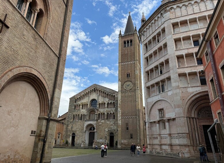 A historic square with a prominent church, a clock tower, and a red-brick building. 3