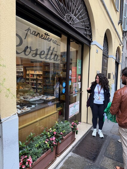 A storefront with a sign reading 'panetteria Rosetta' and a display of baked goods. 4