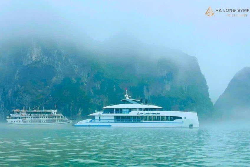 Un crucero blanco llamado 'HA LONG SYMPHY' con montañas al fondo. 2