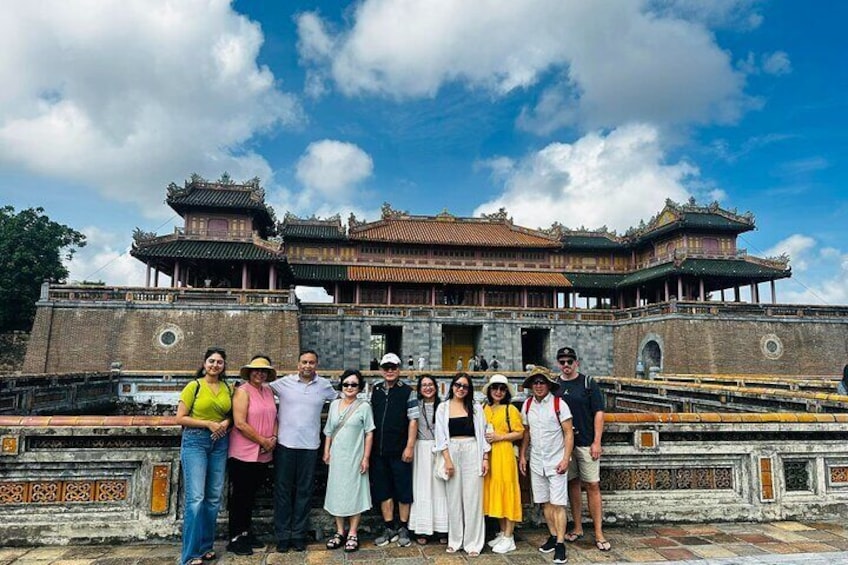 A group of people standing in front of a traditional Chinese building with ornate architecture. 4