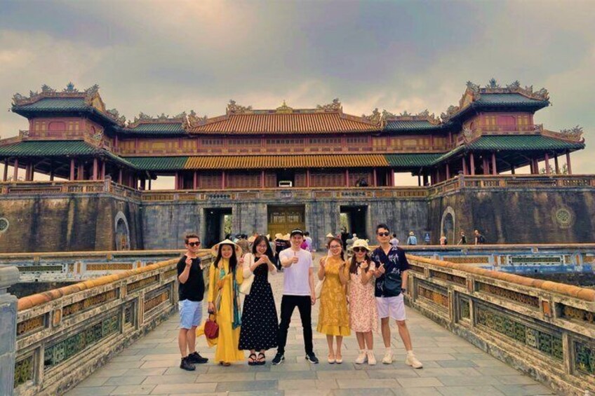 A group of people posing in front of a traditional building with ornate architecture. 3