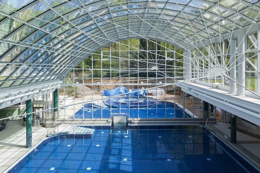 An indoor swimming pool with a glass ceiling and multiple lanes. 3