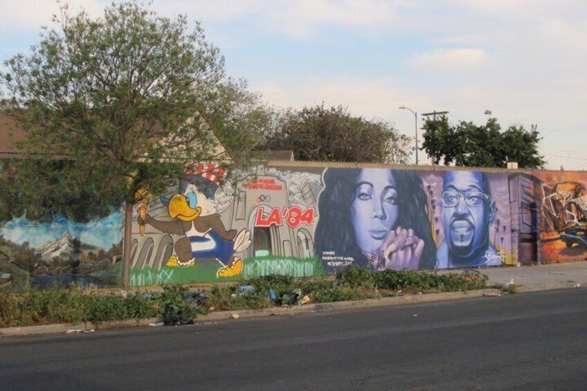 Un mural con un personaje de caricatura, un edificio y una mujer. 5