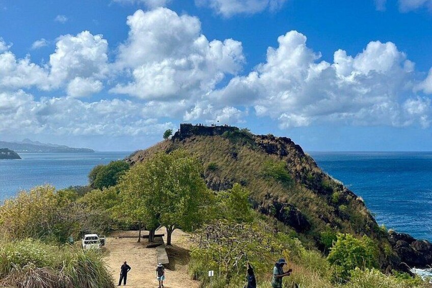 A coastal landscape with a hill, a path, and a vehicle. 3