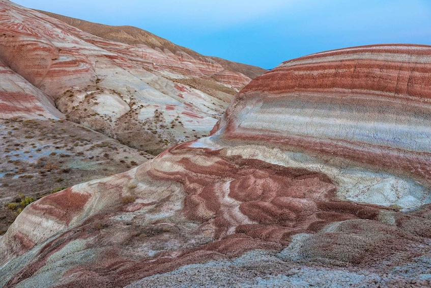 Layered rock formations with distinct red, white, and gray bands. 5
