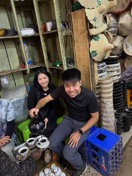 Una persona sirve café en tazas, rodeada de estantes con sombreros y cestas tejidos. 5