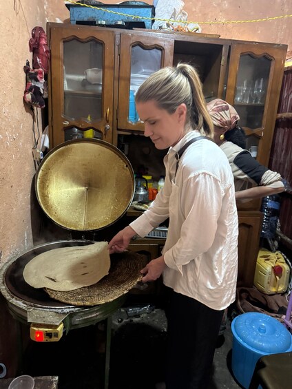 Una persona cocinando con una sartén grande sobre la hornilla. 3