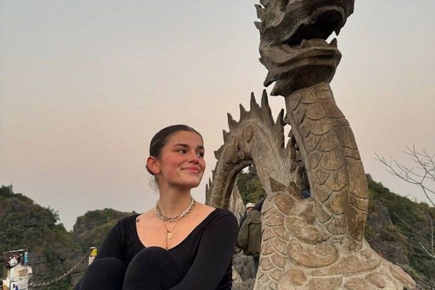 A person standing in front of a large dragon sculpture. 2