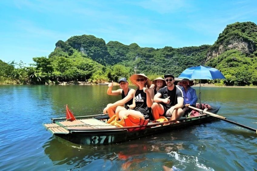A group of people on a boat with a forested landscape in the background. 1