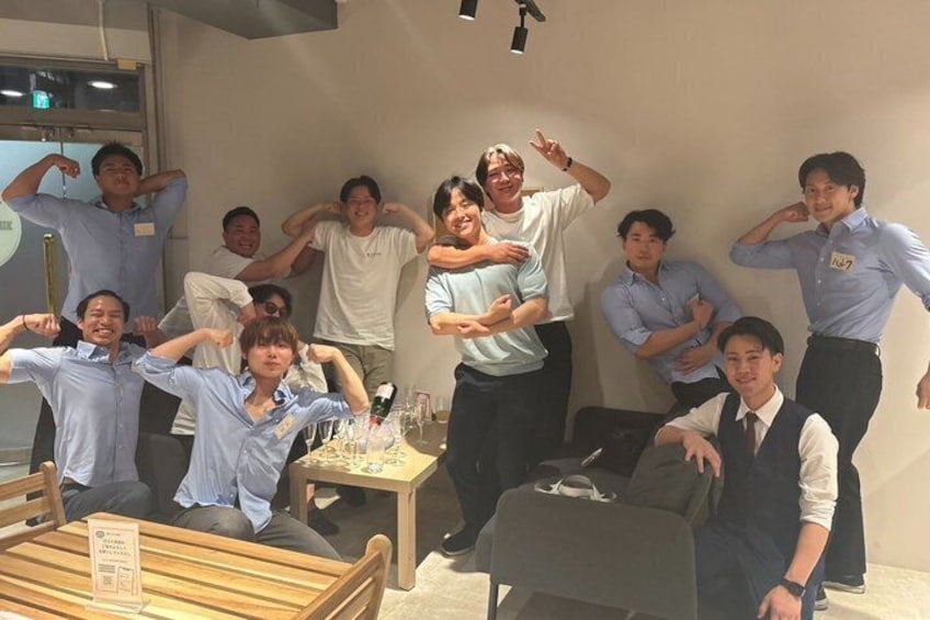 A group of people in a casual indoor setting with tables and chairs, some in business attire. 5