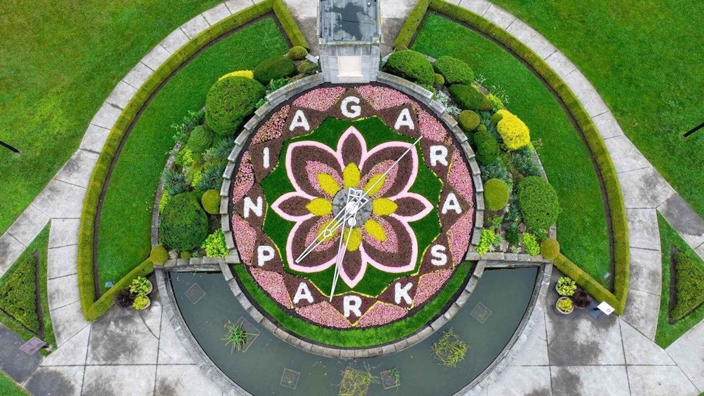 A circular flower-shaped sign with 'IAGAR PARKS' written on it, surrounded by landscaped greenery. 5
