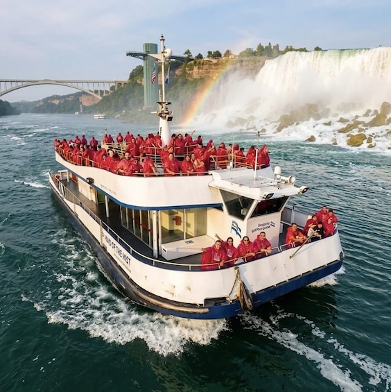 A boat with people in red shirts, a waterfall, and a rainbow in the background. 3