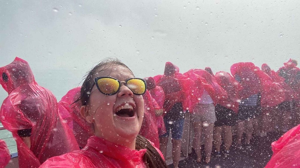 A person in a pink raincoat with yellow goggles amidst a crowd of similarly dressed individuals. 1