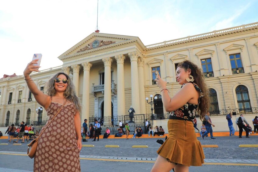 Two people taking a selfie in front of a classical building with columns. 5