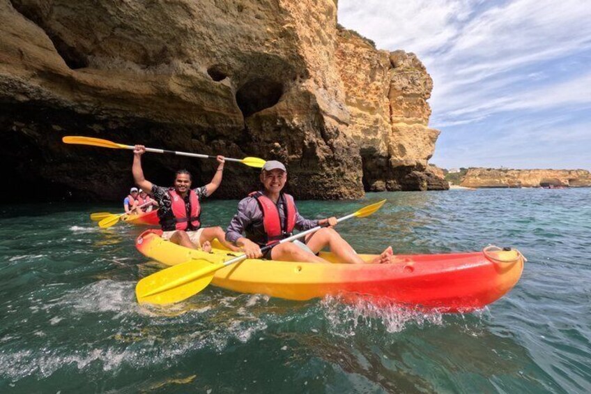 Two people kayaking in a cove with rocky cliffs. 3