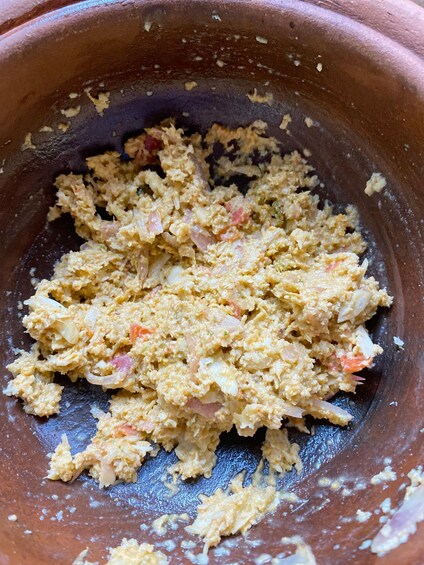 A close-up of a textured food mixture in a brown bowl. 3