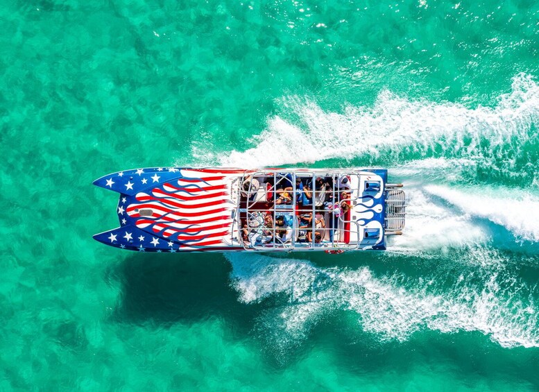 A boat with an American flag design, moving through clear turquoise water. 2