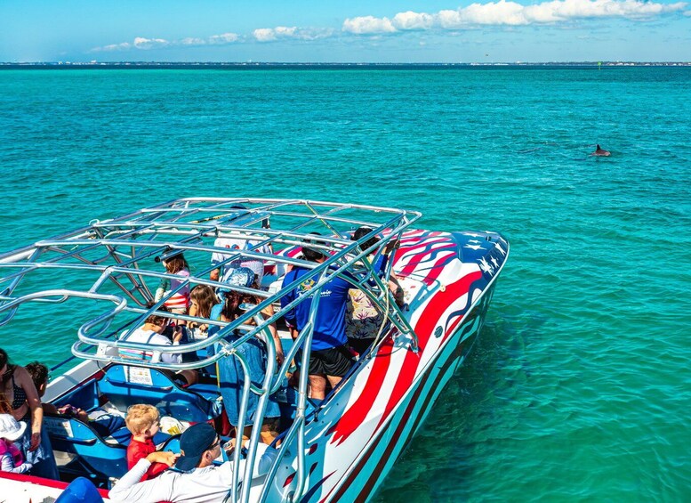 A boat with passengers, clear turquoise water, and a distant shoreline. 4