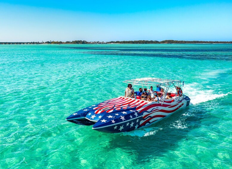 A speedboat with an American flag design on the side, moving through clear turquoise waters. 3