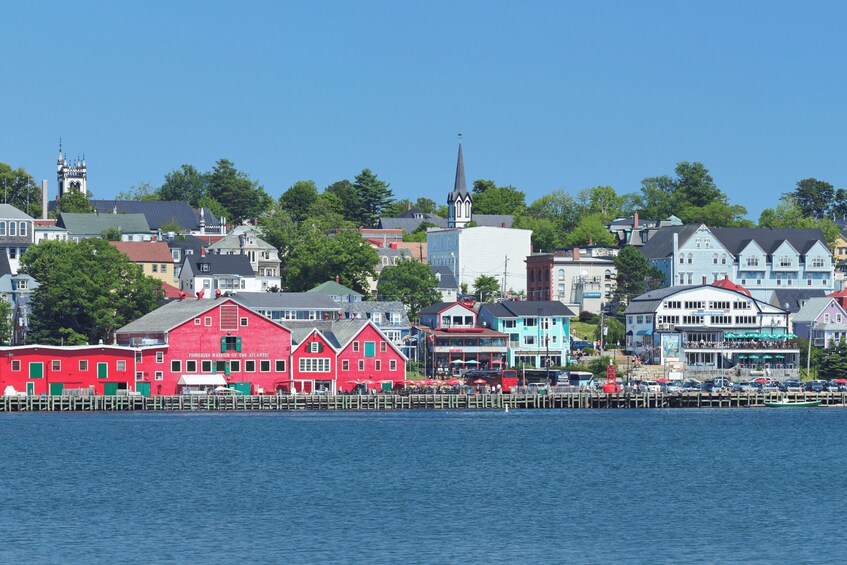 A waterfront town with colorful buildings, including a red building labeled 'Fishermen's Museum of the Atlantic,' and a church with a tall steeple. 1