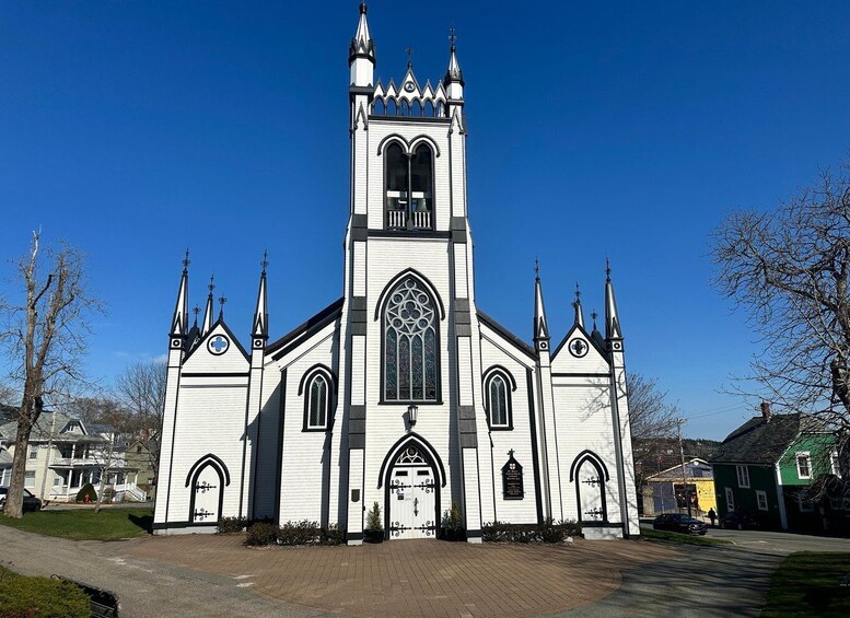 A white church with a tall tower and pointed spires. 3