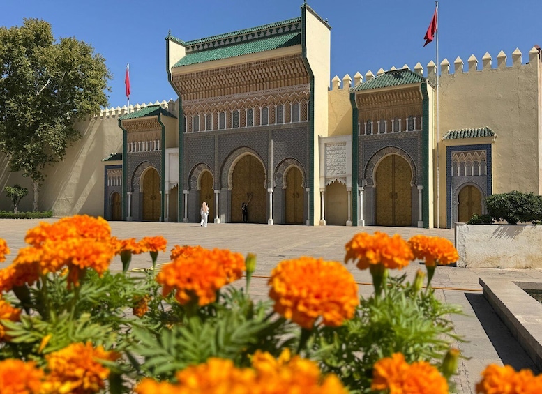 A historic building with arches and a green roof. 3