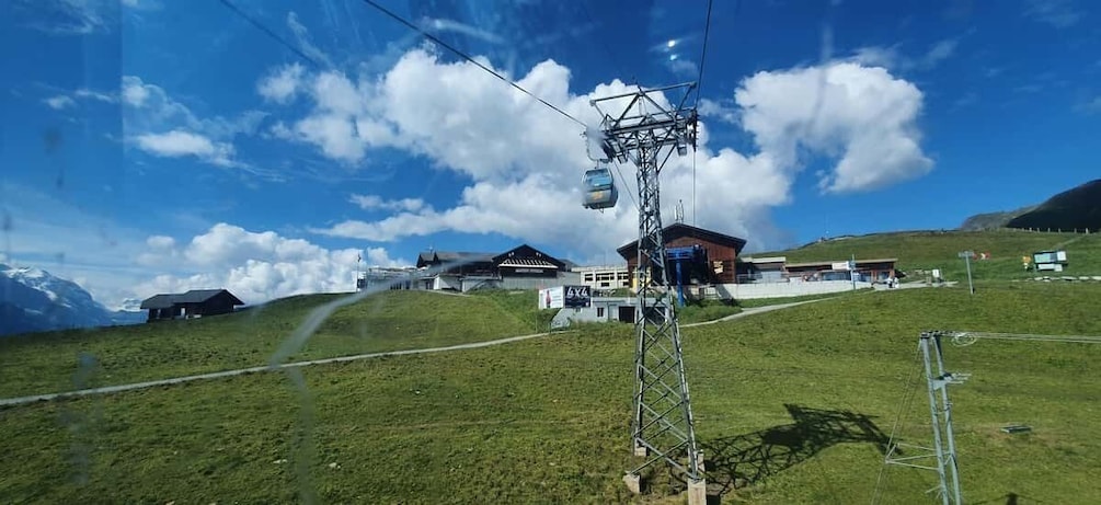 A ski lift, buildings, and a mountain in the background. 4